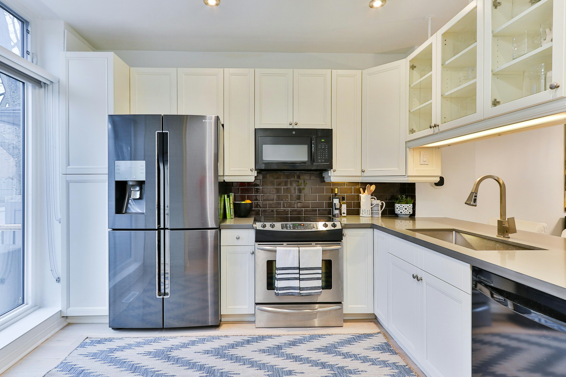 Bright modern kitchen with stainless steel refrigerator and oven